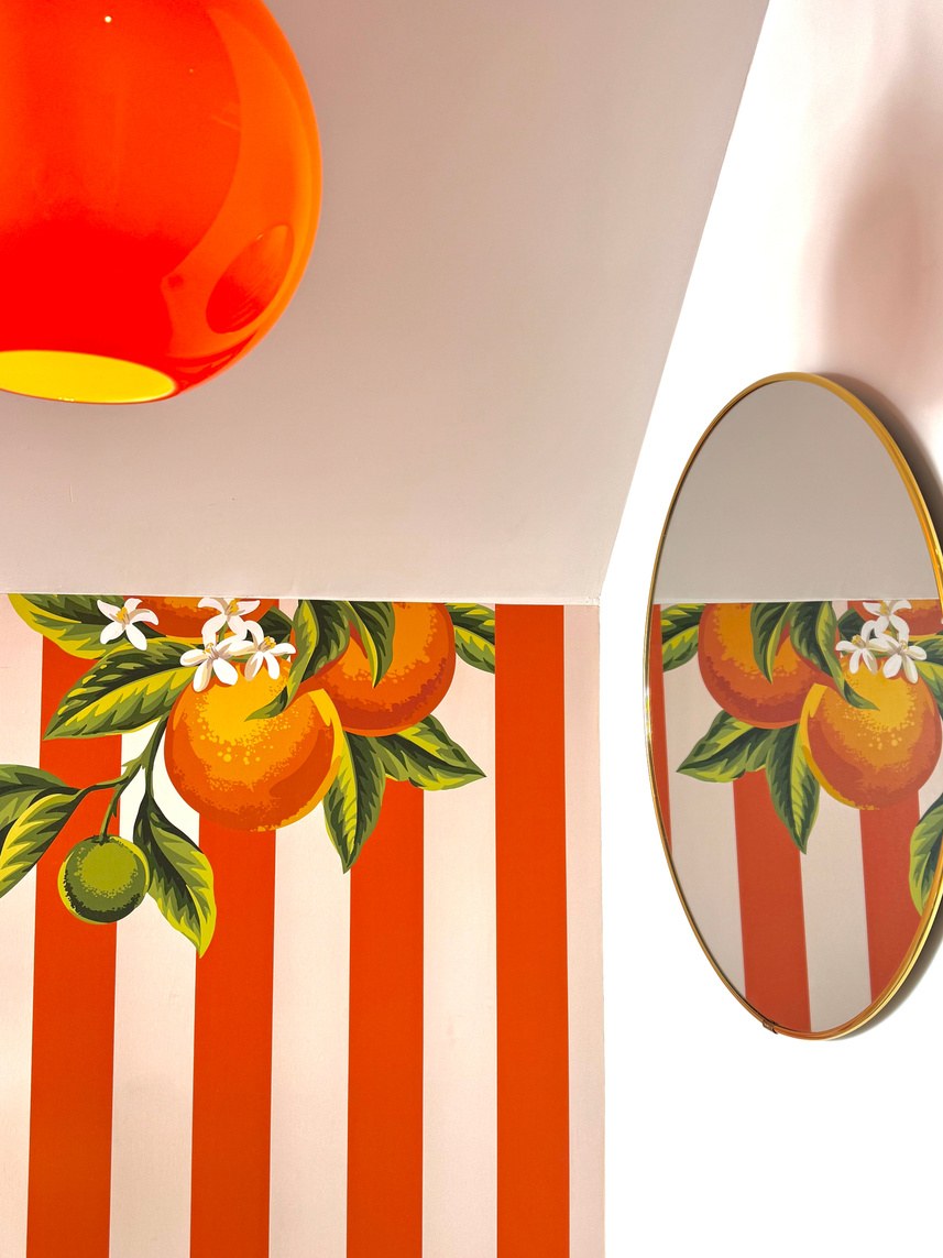 La fresque aux oranges, le miroir rond et la suspension orange de l'agence